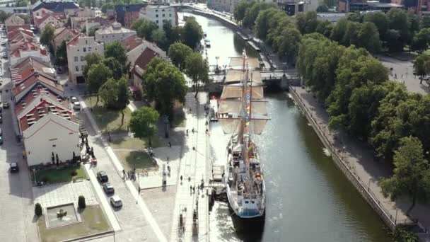 KLAIPEDA, LITHUANIA - JULY, 2019: Aerial flight view of the sailboat Meridianas in the river Dane in old city of Klaipeda. — Stockvideo