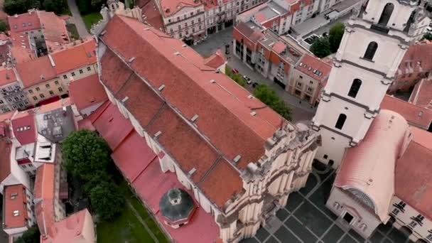 VILNIUS, LITUÂNIA - JULHO, 2019: Vista aérea do drone da igreja St. Johns com torre Bell e telhados da cidade velha . — Vídeo de Stock