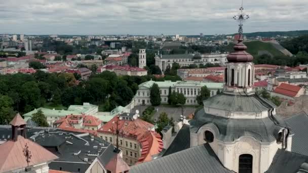 VILNIUS, LITHUANIA - JULY, 2019: Aerial view of the roof, dome of St. Spirits church and beauty of the old city centre. — ストック動画