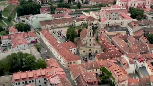VILNIUS, LITHUANIA - JULY, 2019: Aerial drone view of the roofs old city centre and church of Mother of God in Vilnius. — стокове відео