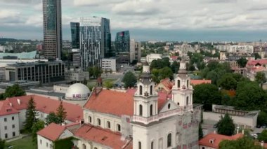 VILNIUS, LITHUANIA - JULY, 2019: Aerial view of the towers of church of Archangel Raphael near business city centers.