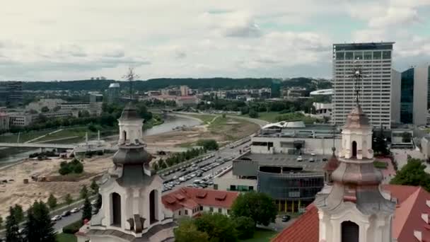 VILNIUS, LITHUANIA - JULY, 2019: Aerial view of the towers Archangel Raphhaels church and Vilnius business center. — ストック動画