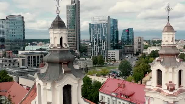 VILNIUS, LITHUANIA - JULY, 2019: Aerial view of the towers Archangel Raphhaels church and Vilnius business center. — Stock video