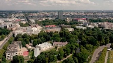 RIGA, LATVIA - MAY, 2019: Aerial top view of the city landscapes with roofs of houses, park and ancient Rigas churches.