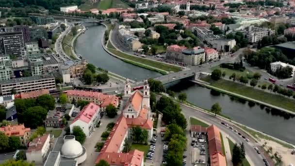 VILNIO, LITUANIA - LUGLIO 2019: Veduta aerea del drone della chiesa dell'Arcangelo Raffaello e ponte sul fiume Neris . — Video Stock