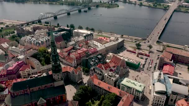 RIGA, LATVIA - MAY, 2019: Aerial top view of the spire of St. Peters cathedral, town hall square and Daugava river. — Stockvideo