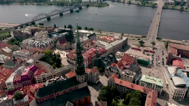 RIGA, LETTONIE - MAI 2019 : Vue aérienne du sommet de la flèche de la cathédrale Saint-Pierre, de la place de la mairie et de la rivière Daugava . — Video