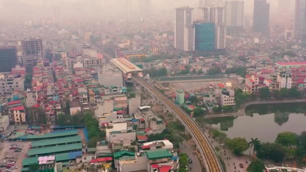 HANOI, VIETNAM - APRIL, 2020: Aerial drone view of the railroad overpass with station and cityscape of Hanoi near lake. — Stock Video