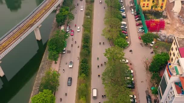 HANOI, VIETNAM - APRIL, 2020: Flygdrönare syn på järnvägen överfart och trafik på vägen i Hanoi nära sjön. — Stockvideo