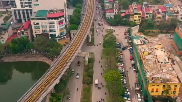 HANOI, VIETNAM - APRIL, 2020: Aerial drone view of the railroad overpass with station and cityscape of Hanoi near lake. — Stock Video