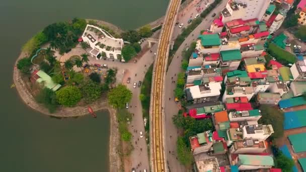 HANOI, VIETNAM - KWIECIEŃ, 2020: Widok z lotu ptaka na wiadukt kolejowy i ruch na drodze w Hanoi w pobliżu jeziora. — Wideo stockowe