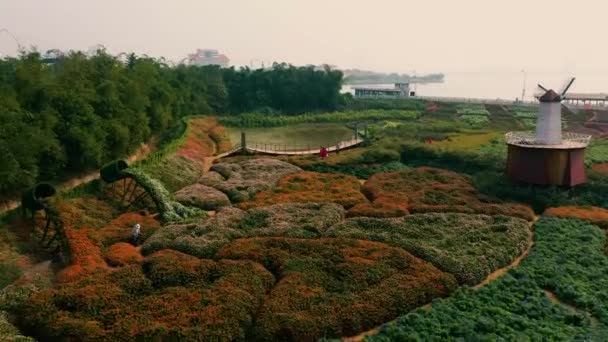 HANOI, VIETNAM - KWIECIEŃ, 2020: Widok z lotu ptaka na ogród kwiatowy z młynem dekoracyjnym i widok na zachodnie jezioro Hanoi. — Wideo stockowe