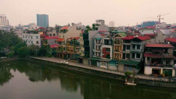 HANOI, VIETNAM - duben 2020: Letecký výhled na střechy domů v blízkosti kanálu a autobusového nádraží v Hanoji. — Stock video