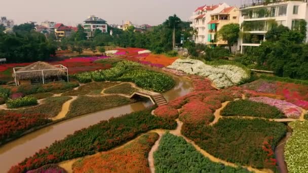 ХАНОЙ, ВЬЕТНАМ - АПРЕЛЬ, 2020: Воздушный беспилотник с видом на цветочный сад с верандами и каналом возле западного озера Ханой . — стоковое видео