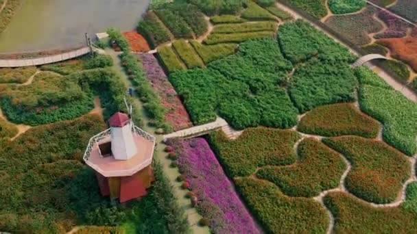 HANOI, VIETNAM - AVRIL 2020 : Vue aérienne du jardin fleuri avec moulin décoratif non loin du lac ouest de Hanoi . — Video