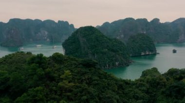 HALONG BAY, VİETNAM - 2020: Vietnam 'da Halong Körfezi tropikal ormanları olan kayalık adaların gökyüzü manzarası.