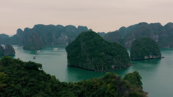 HALONG BAY, VIETNAM - duben 2020: Letecký výhled na skalnaté ostrovy s tropickými lesy zátoky Halong ve Vietnamu. — Stock video