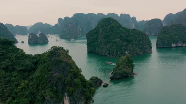 HALONG BAY, VIETNAM - APRIL, 2020: Uitzicht vanuit de lucht op rotsachtige eilanden met tropische bossen van Halong Bay in Vietnam. — Stockvideo