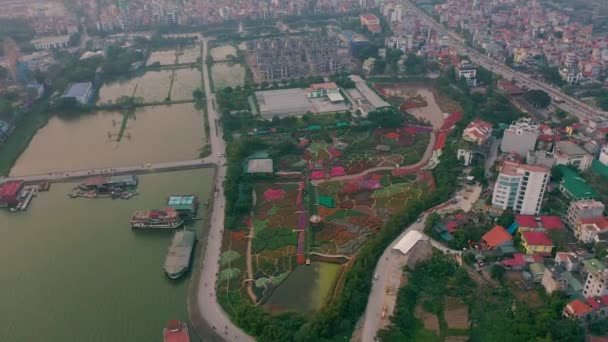 HANOI, VIETNAM - AVRIL 2020 : Vue panoramique aérienne du jardin fleuri près du lac ouest et du paysage urbain de Hanoi . — Video