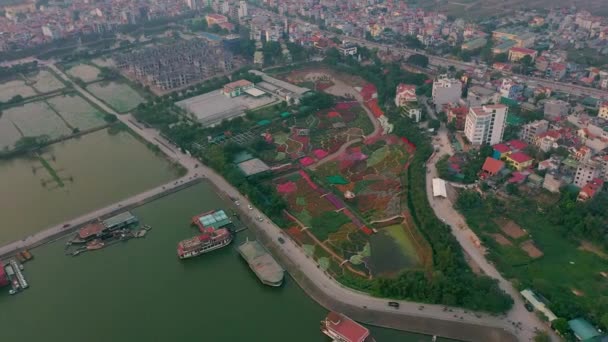 HANOI, VIETNAM - Duben, 2020: Letecký panoramatický výhled na květinovou zahradu u západního jezera a městskou krajinu Hanoje. — Stock video