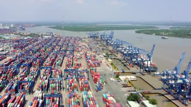 HOCHIMINH, VIETNAM - ABRIL, 2020: Vista aérea del puerto con muchas grúas y contenedores cerca del río en Hochiminh . — Vídeos de Stock