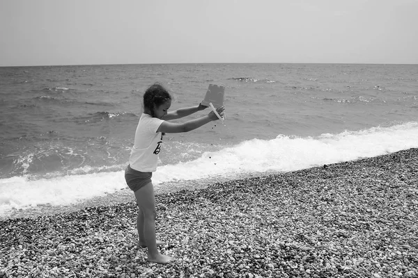 Liten flicka som leker på stranden i närheten av havet. — Stockfoto