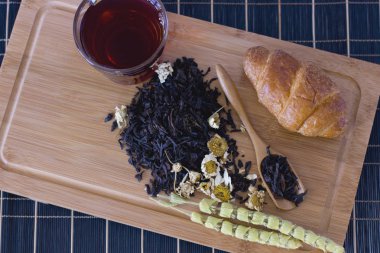 Siyah çay papatya, adaçayı ve kruvasan ahşap tepsi