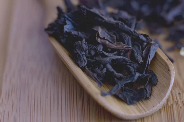 Chá de folha preta em uma colher de madeira — Fotografia de Stock