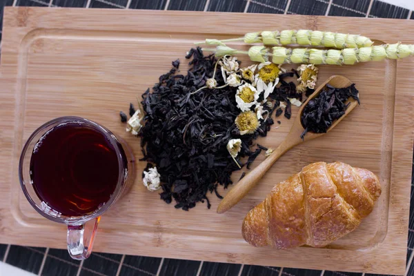 Siyah çay papatya, adaçayı ve kruvasan ahşap tepsi