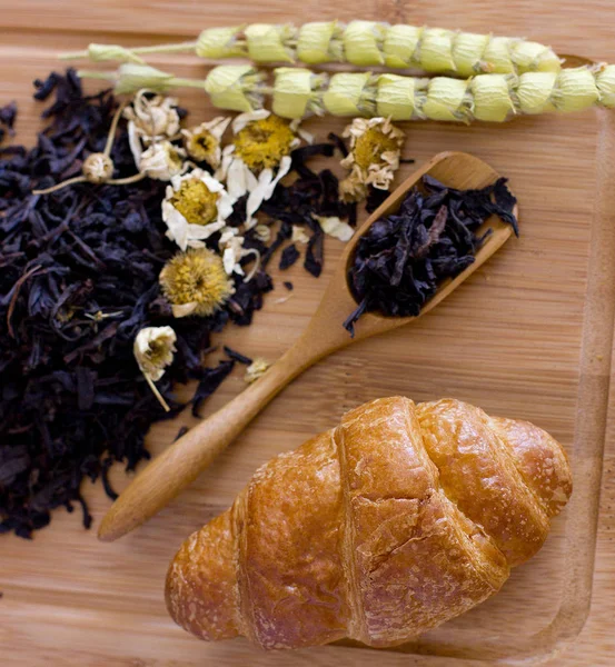 Chá preto com camomila, salva e croissant na bandeja de madeira — Fotografia de Stock