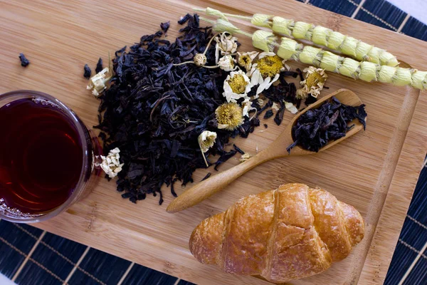 Siyah çay papatya, adaçayı ve kruvasan ahşap tepsi