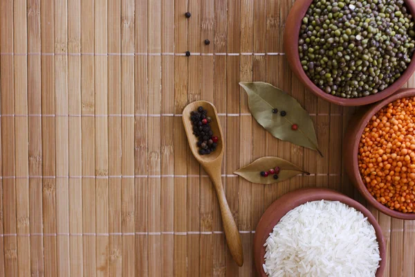 White rice, red lentils and green peas mache on wooden tray. Bay — Stock Photo, Image