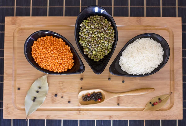 Arroz branco, lentilhas vermelhas e ervilhas verdes mache em um vidro preto pl — Fotografia de Stock