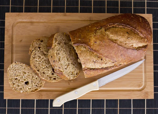 Pão de centeio com cereais na mesa de madeira — Fotografia de Stock