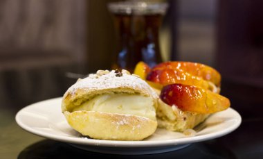 Bun muhallebi ve pudra şekeri ile. Sır şeftalili pasta.