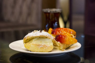 Bun muhallebi ve pudra şekeri ile. Sır şeftalili pasta.