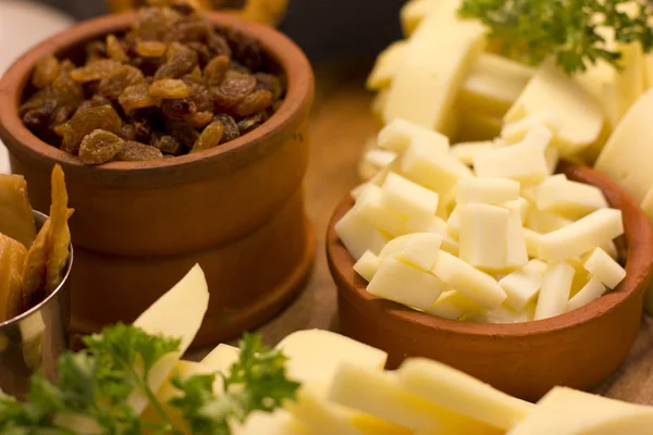 Kil kase dilimlenmiş çedar peynir ve kuru üzüm. Seçici odak