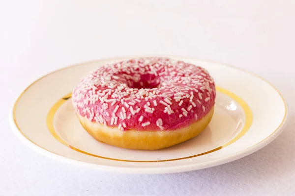 Ярко розовый пончик на белом фоне — стоковое фото