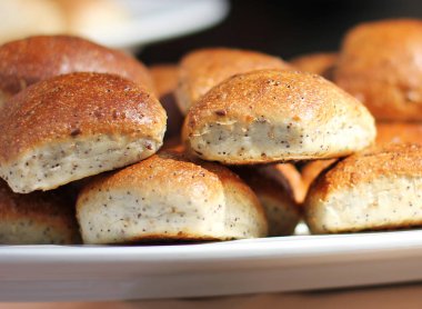 Fırından yeni çıkmış buğday ekmeği ile beyaz bir plaka üzerinde haşhaş tohumu