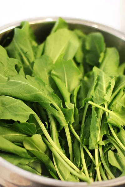 Green leaves of arugula in silver bowl — Stock Photo, Image