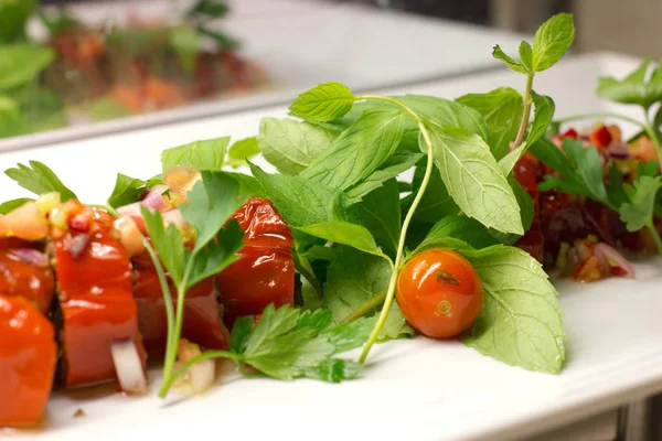Сладкий красный перец, фаршированный свежими овощами на белой тарелке — стоковое фото