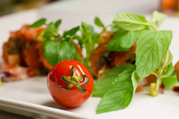 Tomate cherry con verduras frescas y menta en un plato blanco — Foto de Stock