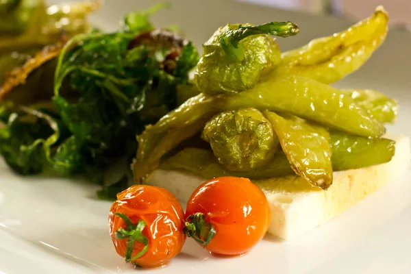 Tomate cherry al horno con verduras horneadas y pimienta verde en un — Foto de Stock