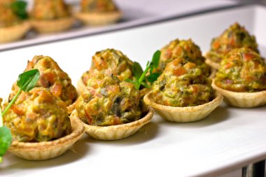 Beyaz porselen di pişmiş sebze ve otlar ile Tartlets