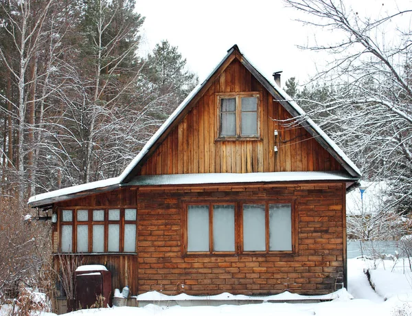 Velha casa de madeira rústica na floresta nevada no inverno — Fotografia de Stock