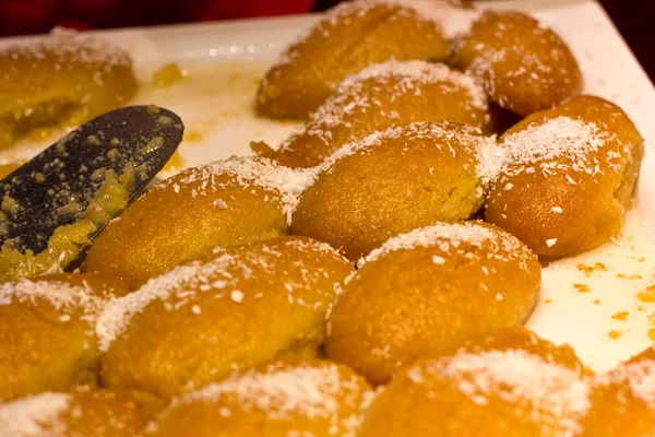 Türkische Süßigkeiten mit Kokosraspeln auf einem weißen Teller mit einem silbernen — Stockfoto