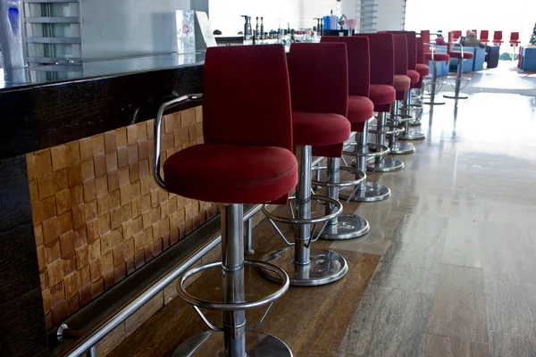 Bar with a long counter and high bar red chairs