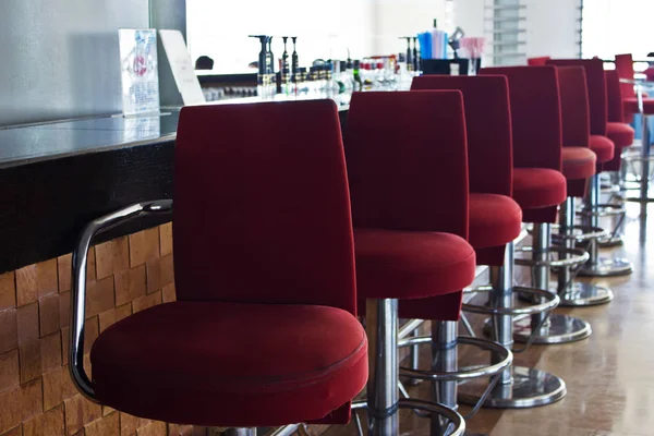Bar mit langem Tresen und roten Stühlen lizenzfreie Stockbilder