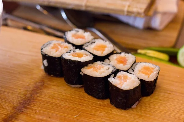 Voorbereiding van Japanse rollen van zalm. Rollen op een houten boa — Stockfoto