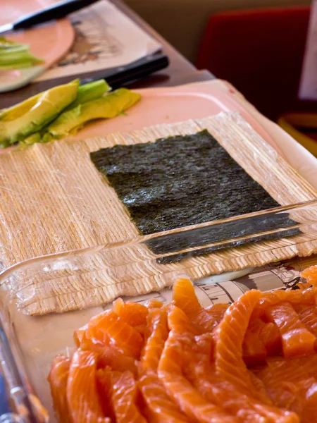 Příprava japonských závitky z lososa. Rohlíky na dřevěné boa — Stock fotografie
